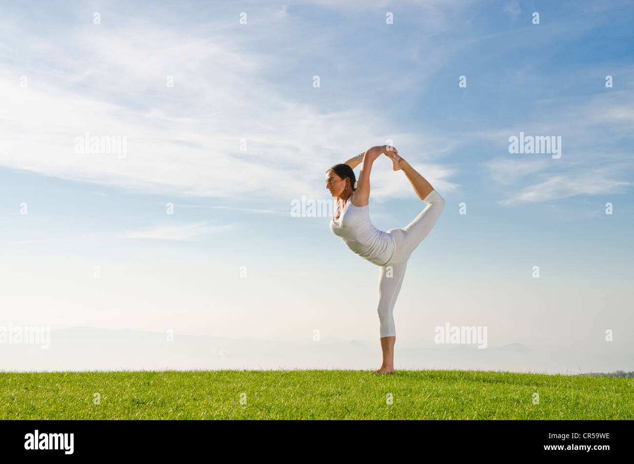 Mujer joven practicar Hatha yoga al aire libre, mostrando la pose natarajasana, Lord Shiva pose , República Checa, Europa Foto de stock