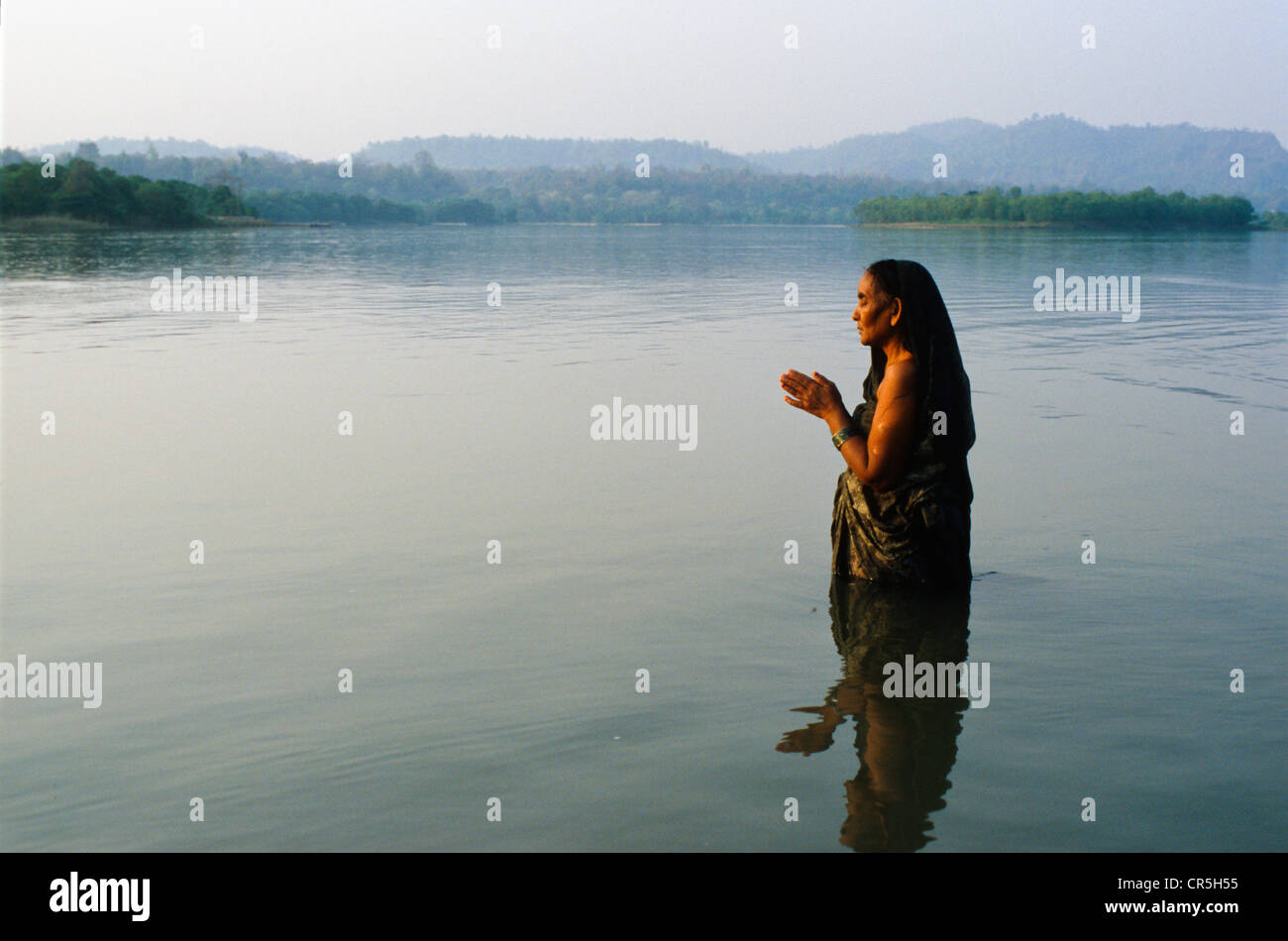 Mujer orando a Dios el frío en el agua cristalina del río Ganges, Haridwar, Uttarakhand, antiguamente Uttaranchal, India, Asia Foto de stock