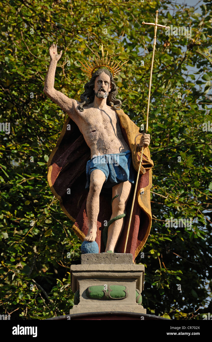 La escultura del Cristo, mano derecha levantada en bendición, sosteniendo un crucifijo en su mano izquierda, a la entrada de Salvatorkirche Foto de stock