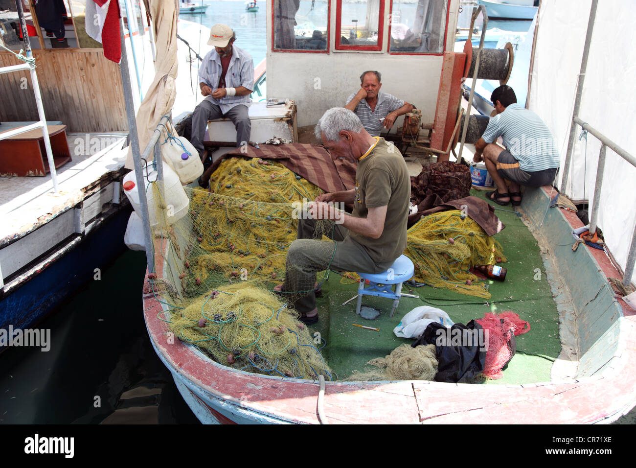 Arreglando las redes de pesca, Puerto de Kusadasi, Kusadasi, Turquía, Asia Foto de stock