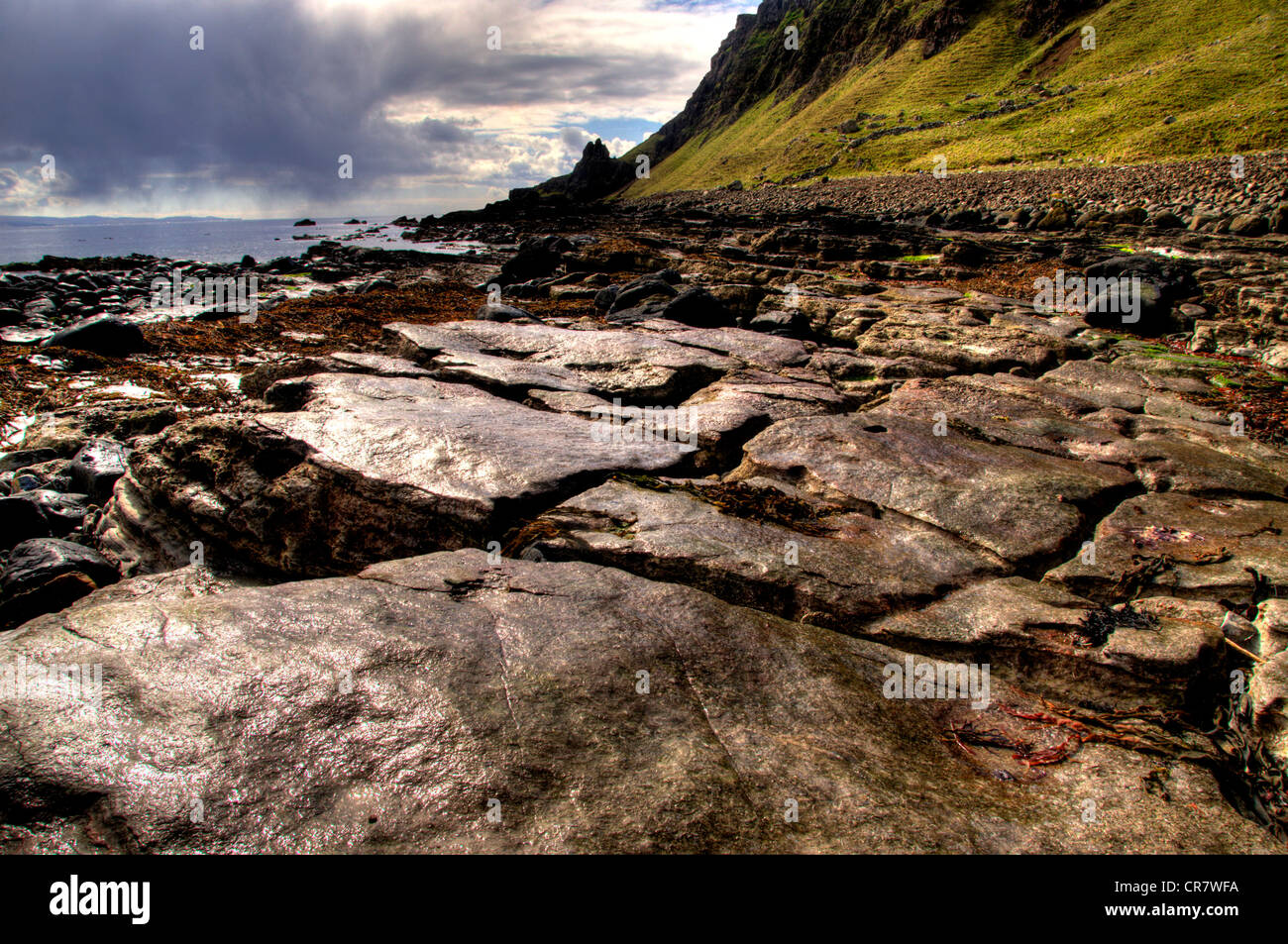 Un paisaje de camas mor bay isla de estiércol con un interesante primer plano de rocas húmedas tomadas justo después de una tormenta Foto de stock