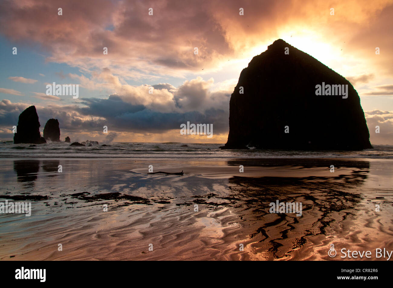 Sunset silouttes Haystack rock y las agujas de Canon playa a lo largo de la costa del pacífico de Oregon. Foto de stock