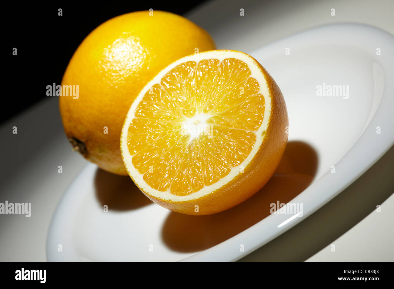 Naranja (Citrus sinensis) en una placa blanca. Foto de stock