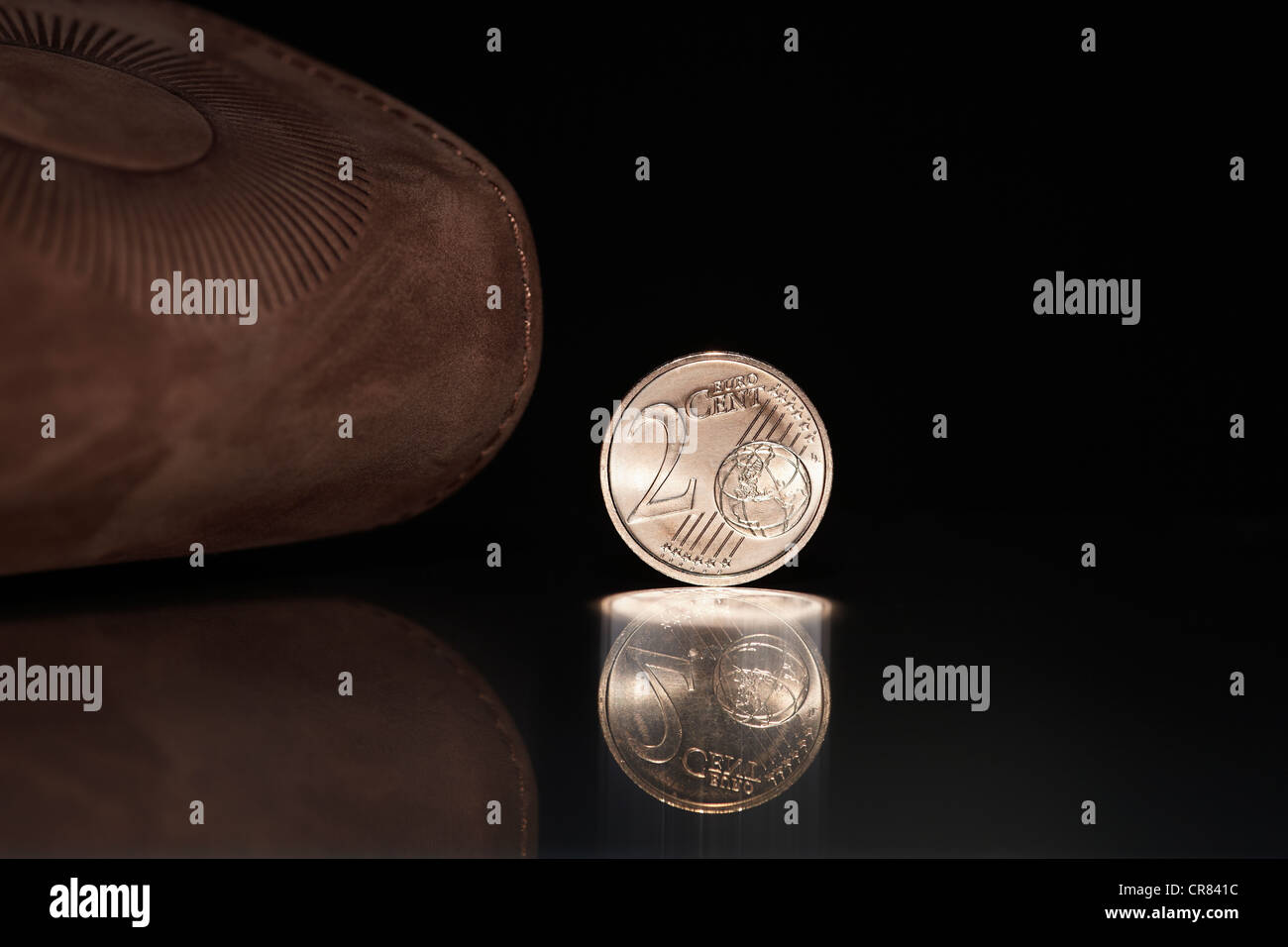 La moneda de 2 céntimos de euro en frente de una cartera o monedero de cuero marrón Foto de stock
