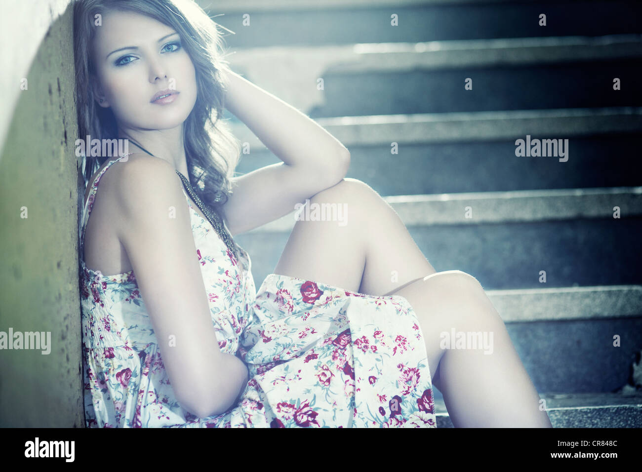 Mujer joven llevaba un vestido de verano sentado en una escalera Foto de stock