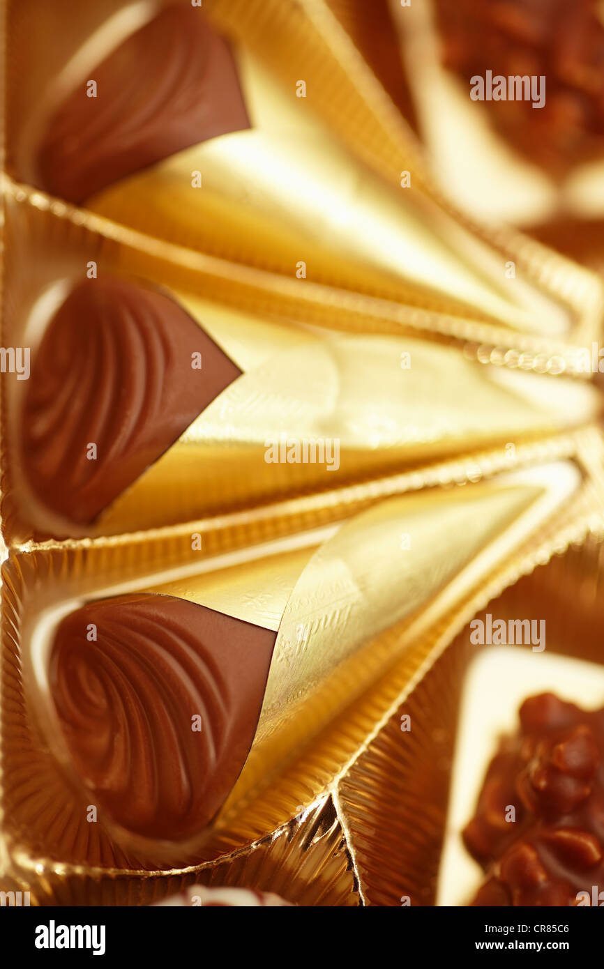 Chocolates en una caja de bombones de oro Foto de stock