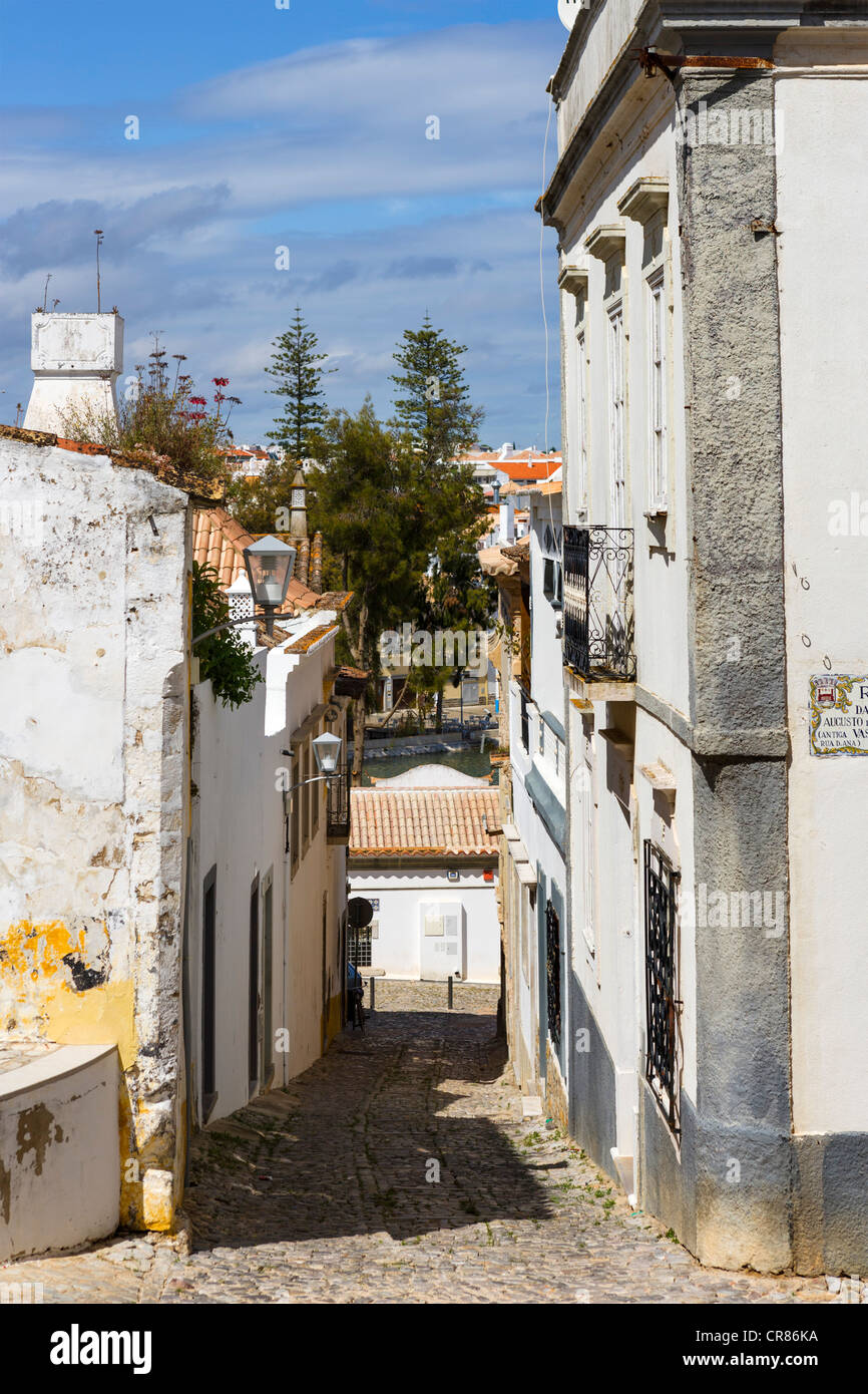 Estrecha calle de adoquines en el casco antiguo de la ciudad, Tavira, Algarve, Portugal Foto de stock
