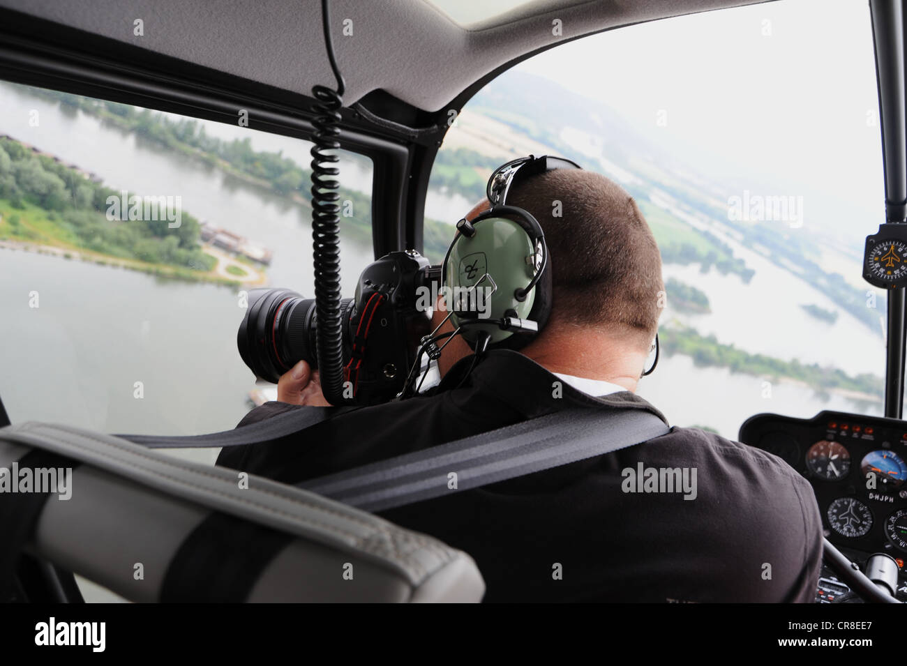 Fotógrafo tomando fotografías aéreas desde un helicóptero Foto de stock