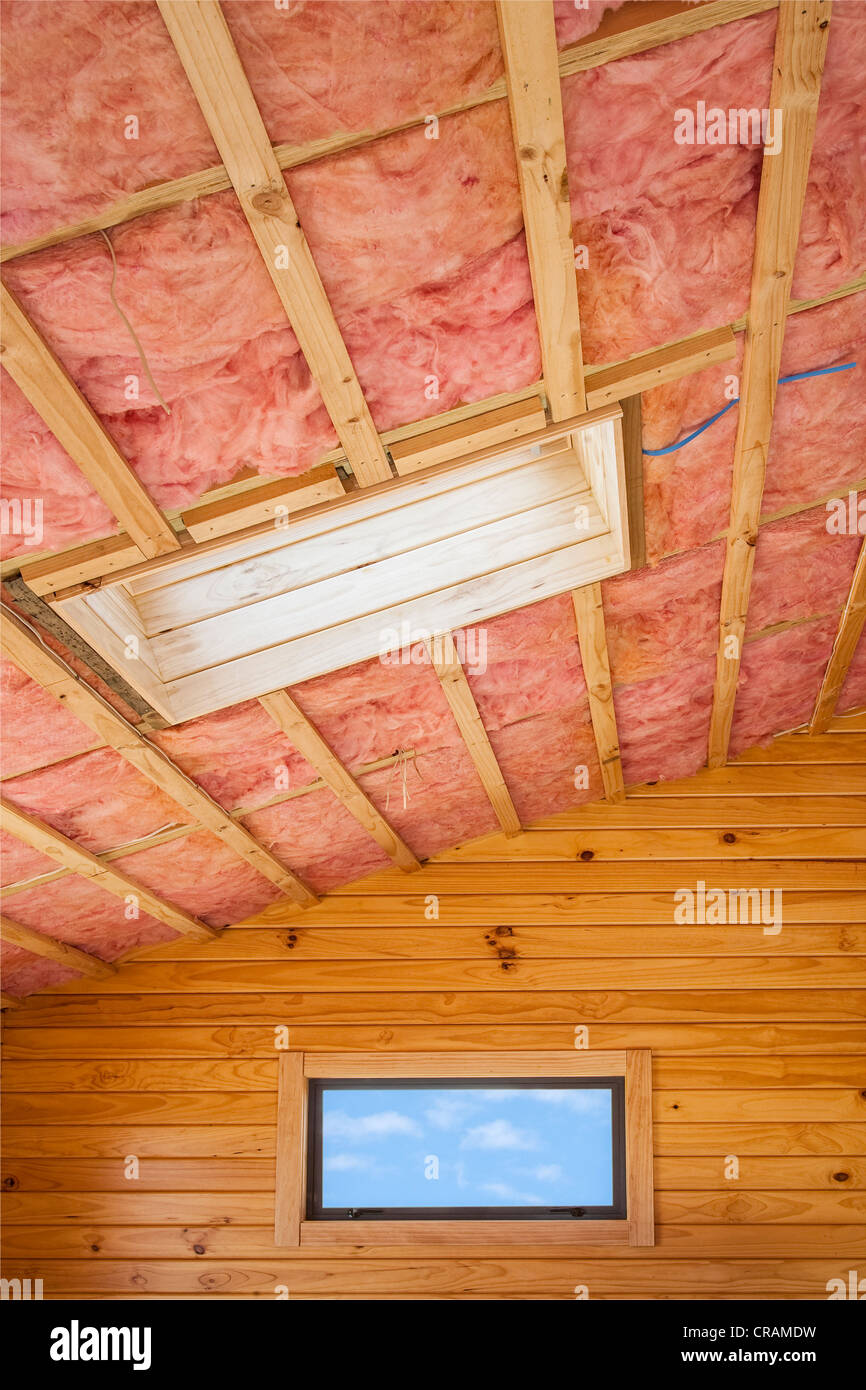 Aislamiento de fibra de vidrio instalado en la viguería de madera de una casa. Foto de stock