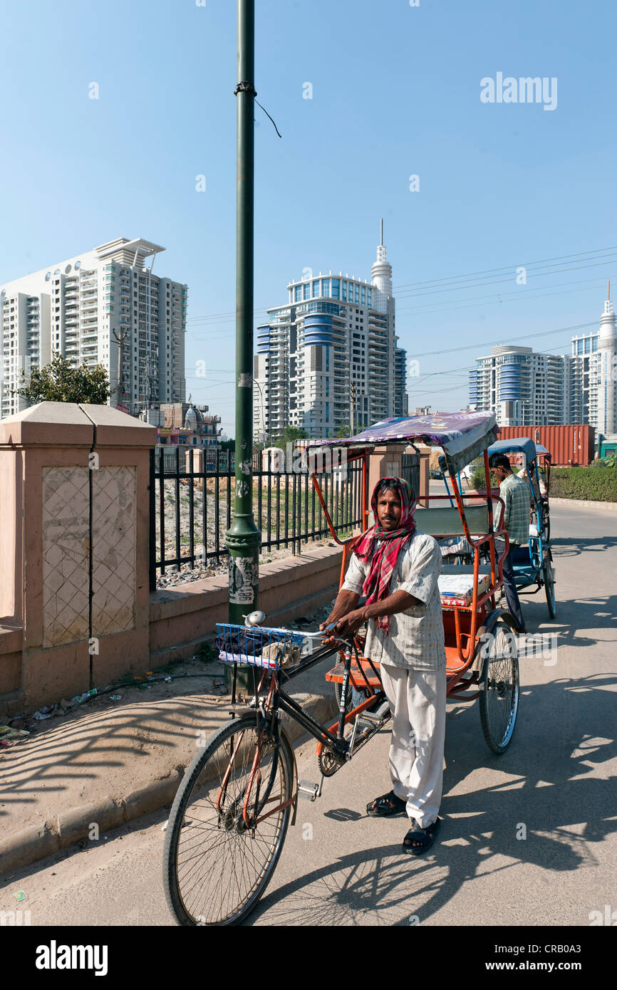 Los conductores de rickshaw en frente del nuevo rascacielos residencial en Gurgaon, Haryana, India, Asia Foto de stock