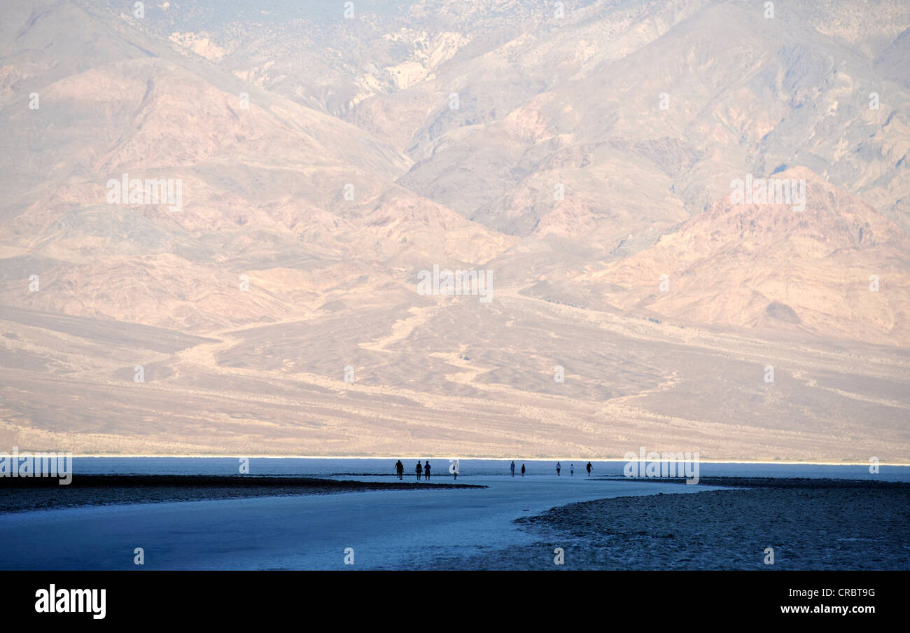 Los turistas al amanecer en el salar de Badwater, Panamint rango en la espalda, el Parque Nacional Valle de la muerte, el desierto de Mojave Foto de stock
