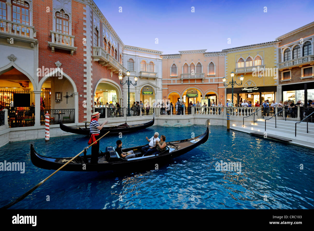 Gondolero en una góndola para atraer a turistas en callejuelas venecianas simulado bajo un cielo artificial, Canale Grande Foto de stock