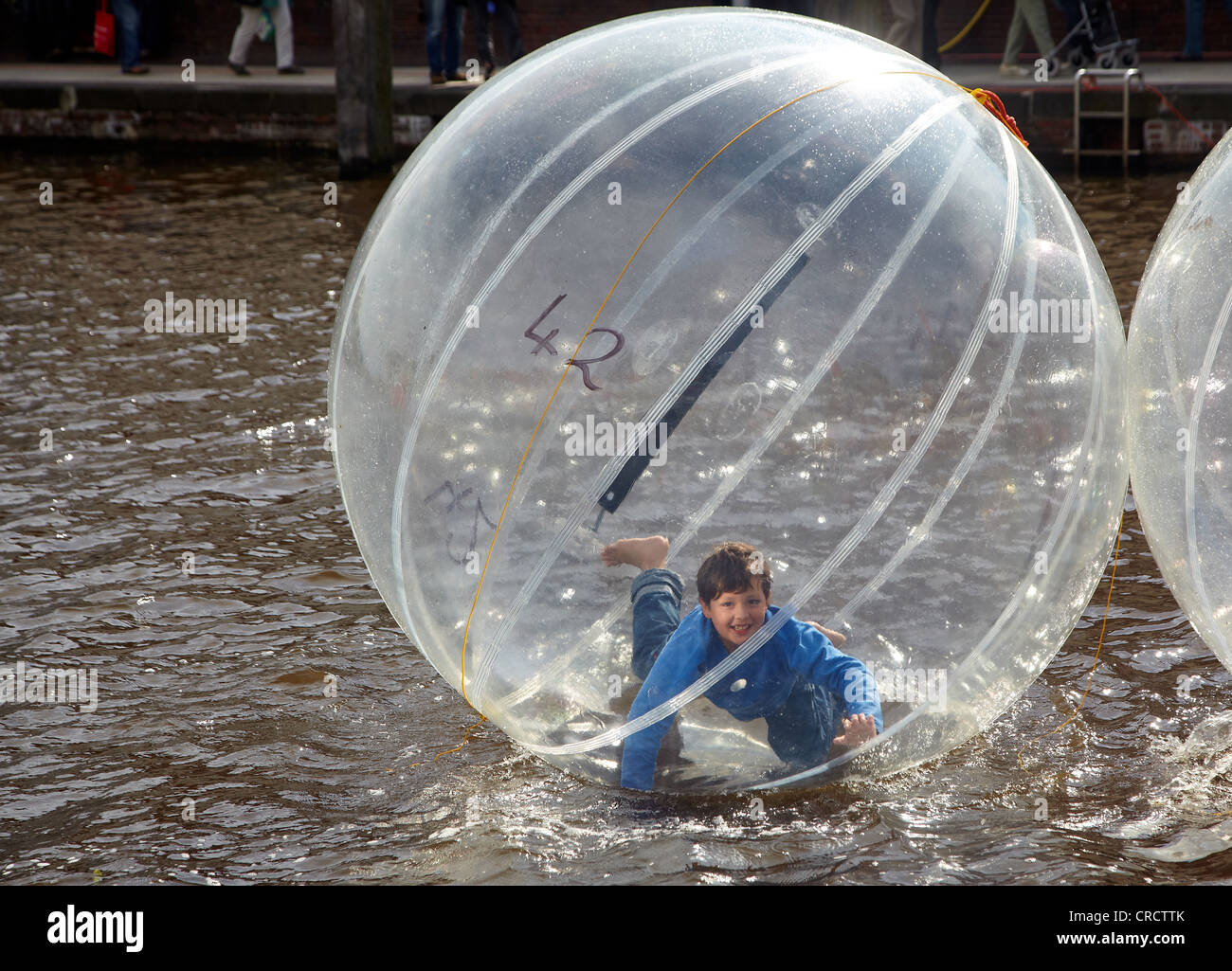 Niños en una bola de aire sobre el agua, Emden, Baja Sajonia, Alemania, Europa Foto de stock