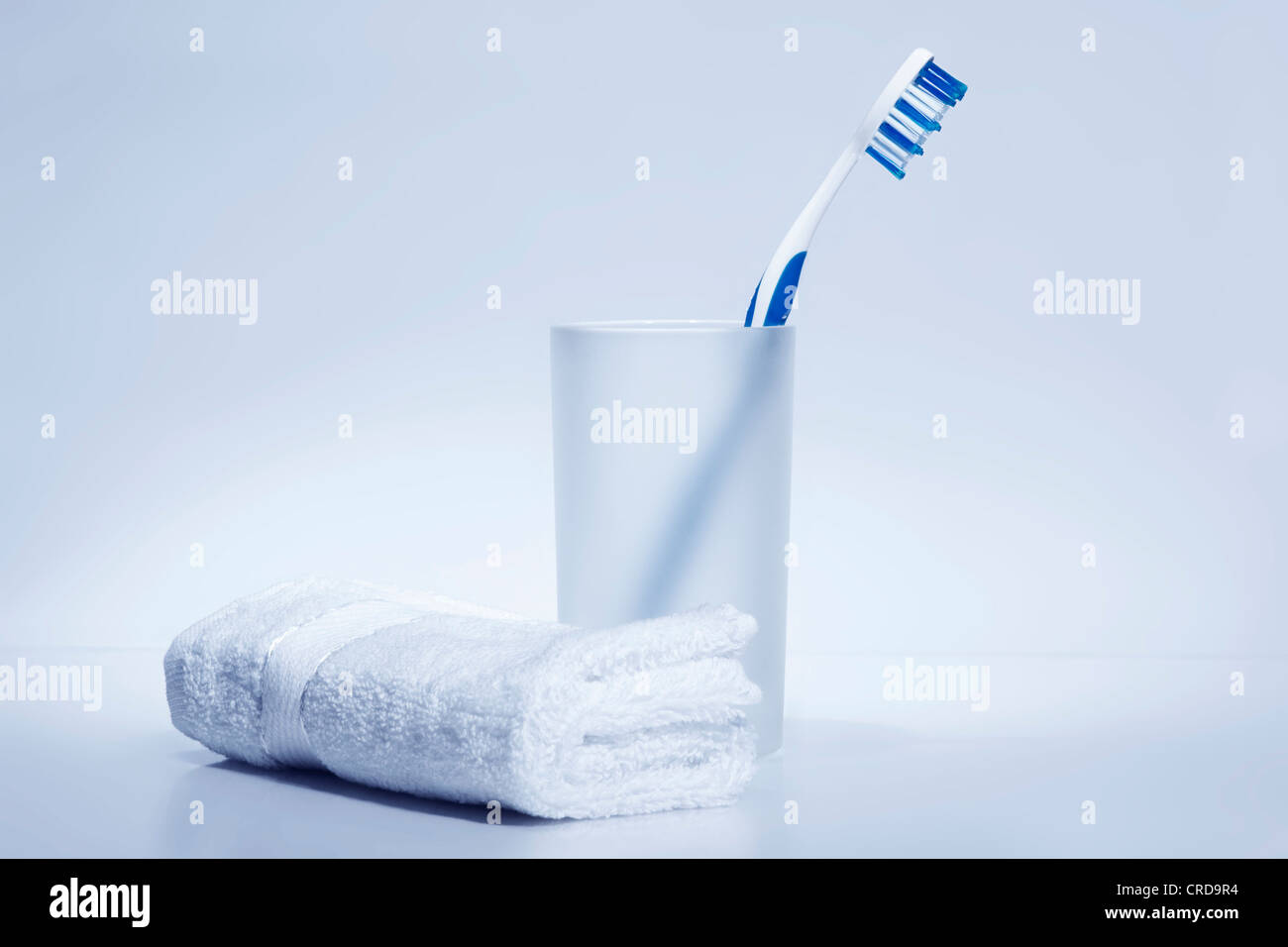 Cepillo de dientes en el cepillo de dientes secadora al lado toalla blanca Foto de stock