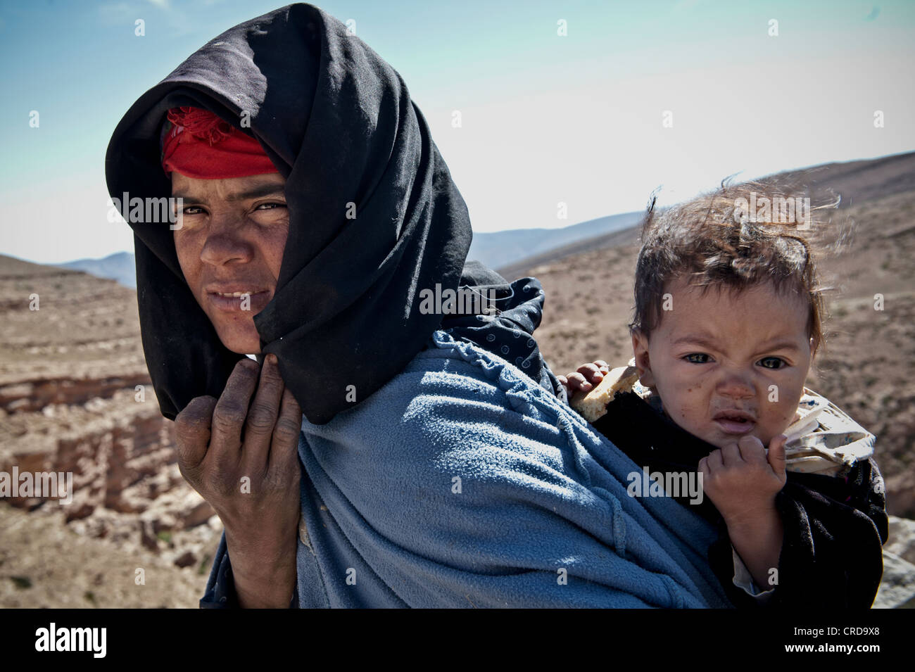 Nómada bereber madre llevar a su hijo a las montañas del Atlas, Marruecos Foto de stock