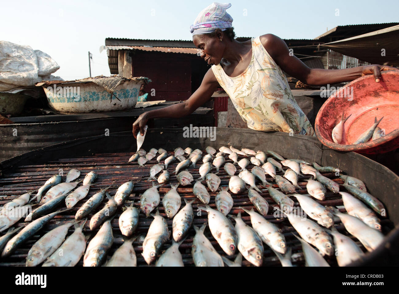 Una mujer establece pez somke en la barriada de West Point de Monrovia, la capital del condado de Montserrado, Liberia el lunes 2 de abril, 2012. Foto de stock