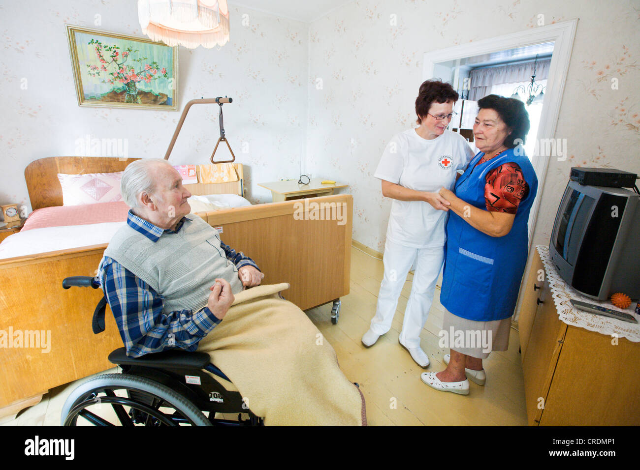 Atención ambulatoria proporcionada por la Cruz Roja Alemana, la enfermera Anke Lehmann visita una pareja de ancianos cada mañana para ayudar a la esposa de Foto de stock