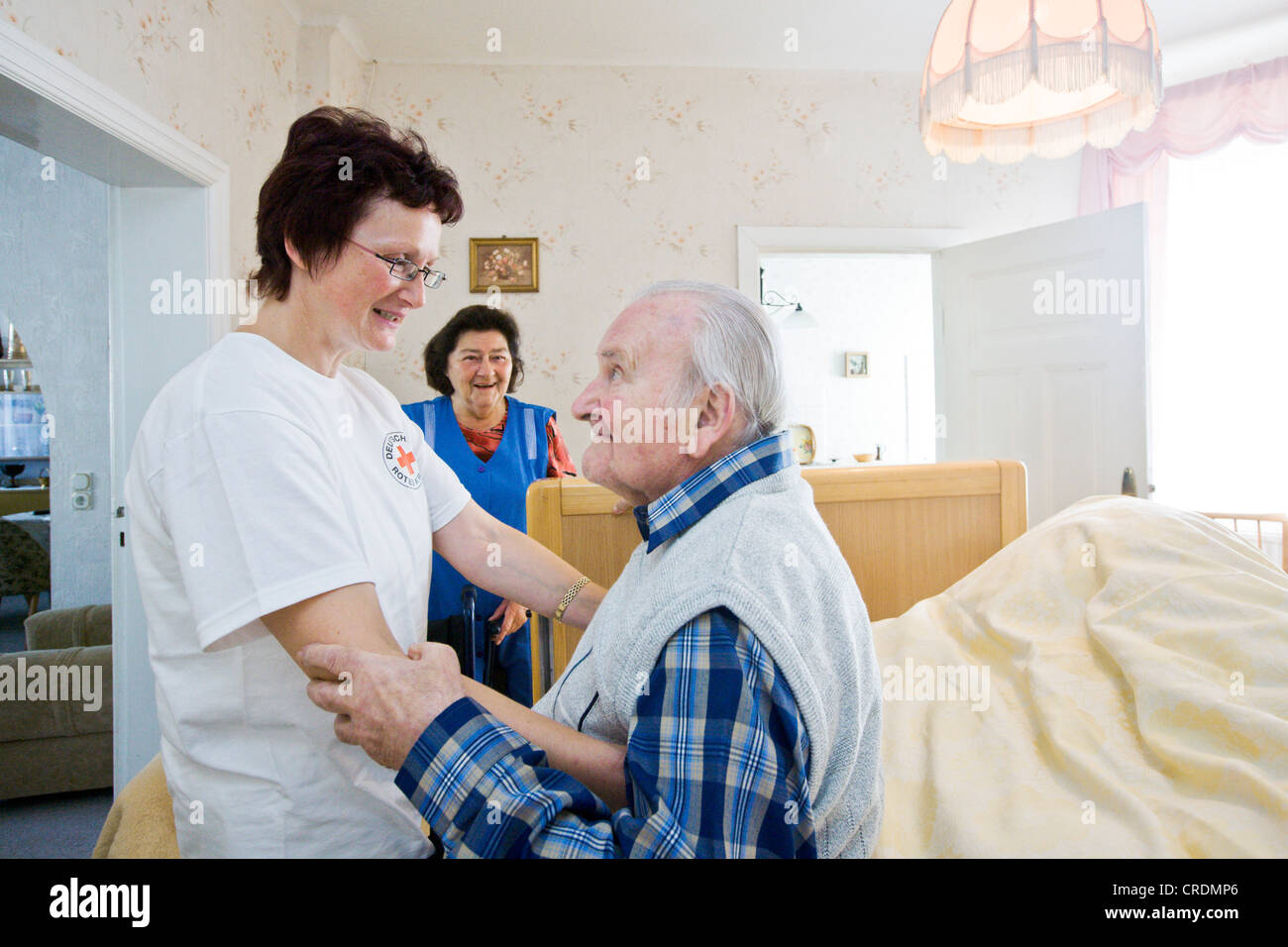 Atención ambulatoria proporcionada por la Cruz Roja Alemana, la enfermera Anke Lehmann visita una pareja de ancianos cada mañana para ayudar a la esposa de Foto de stock