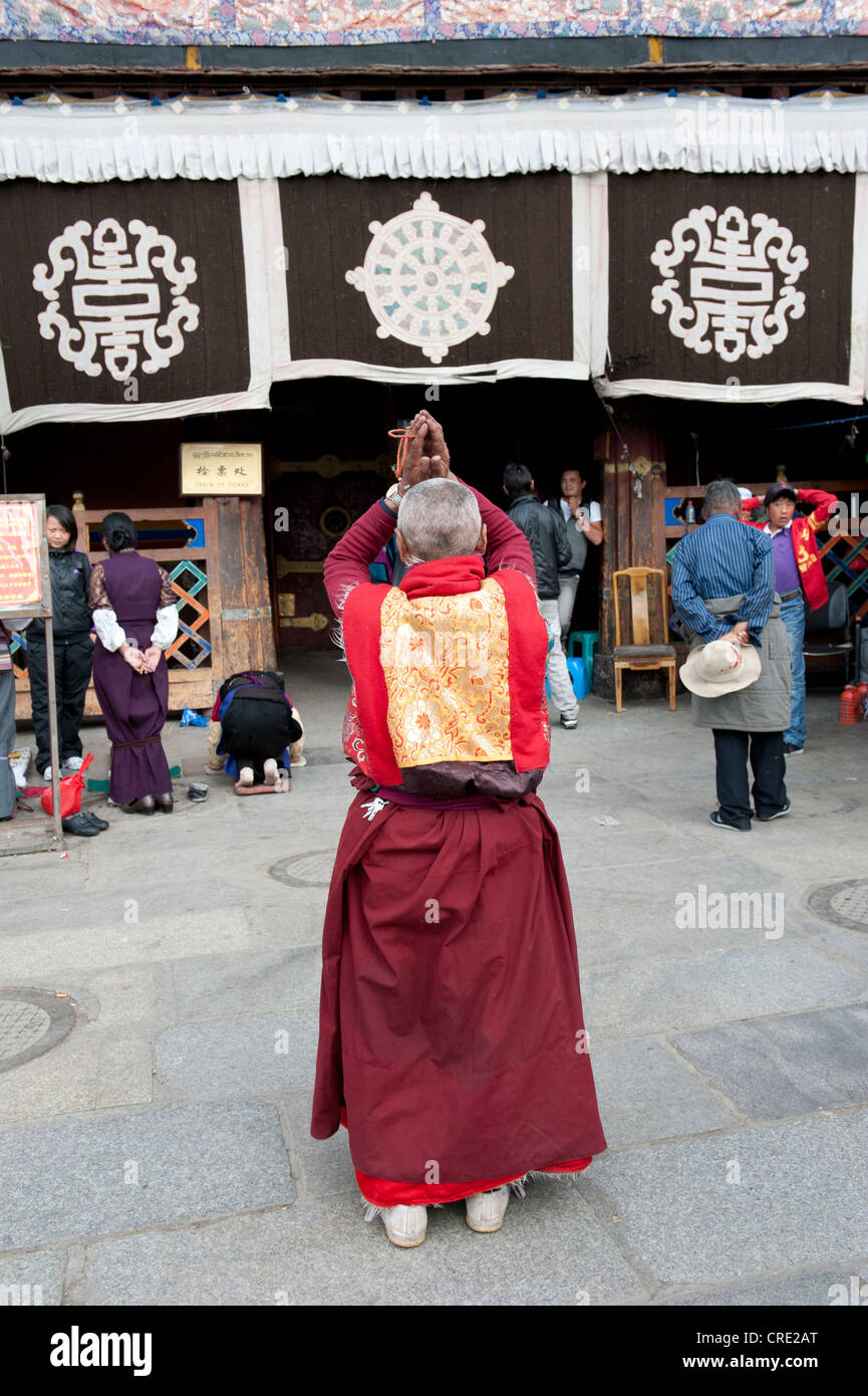 Monje budista tibetano, orando delante del templo Jokhang, Plaza de Barkhor, Lhasa, Himalaya, Tíbet, China, Asia Foto de stock