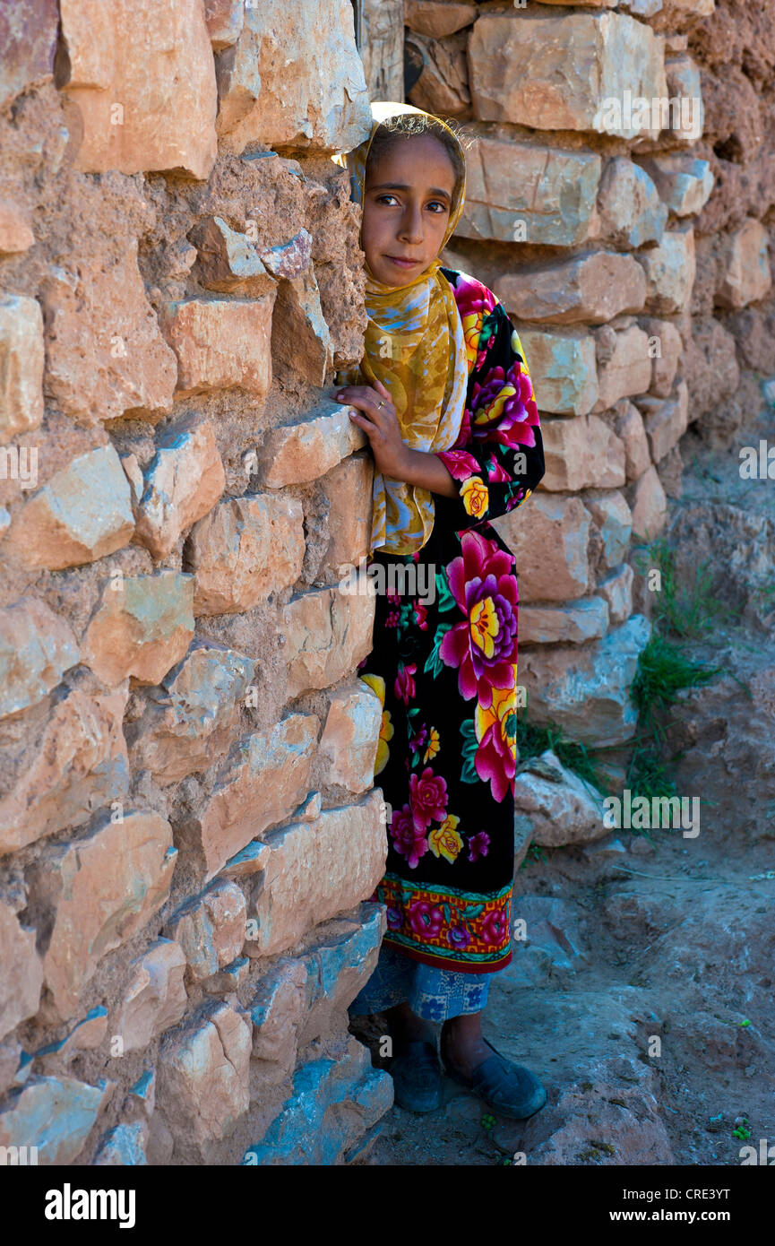 Chica, la berberina, mirando curiosamente desde detrás de un muro, montañas del Atlas Medio, Marruecos, África Foto de stock