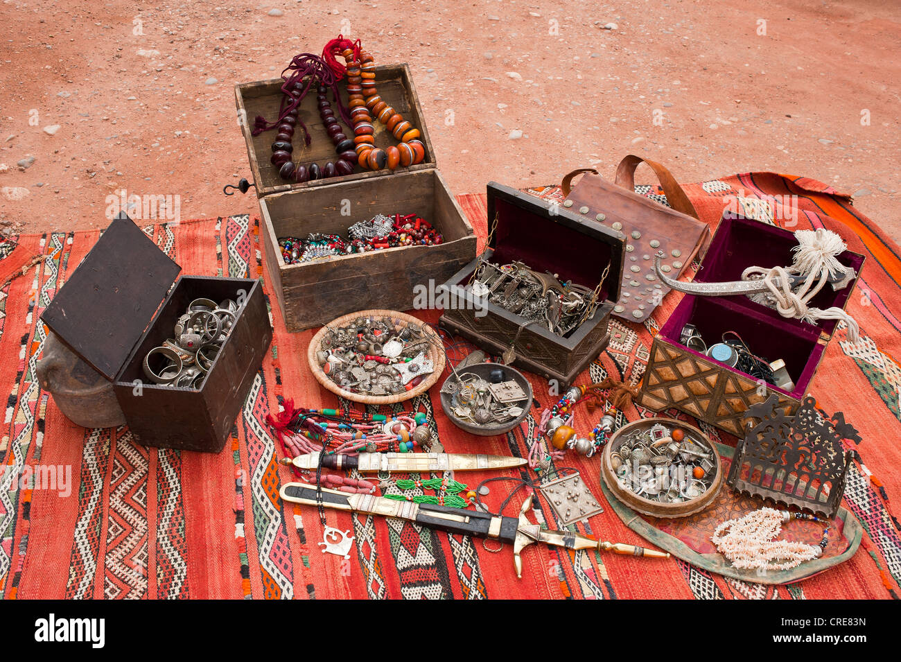 Poco cofres del tesoro, joyas y decoración oriental tradicional Touareg cuchillo extendido sobre una alfombra, Marruecos, África Foto de stock