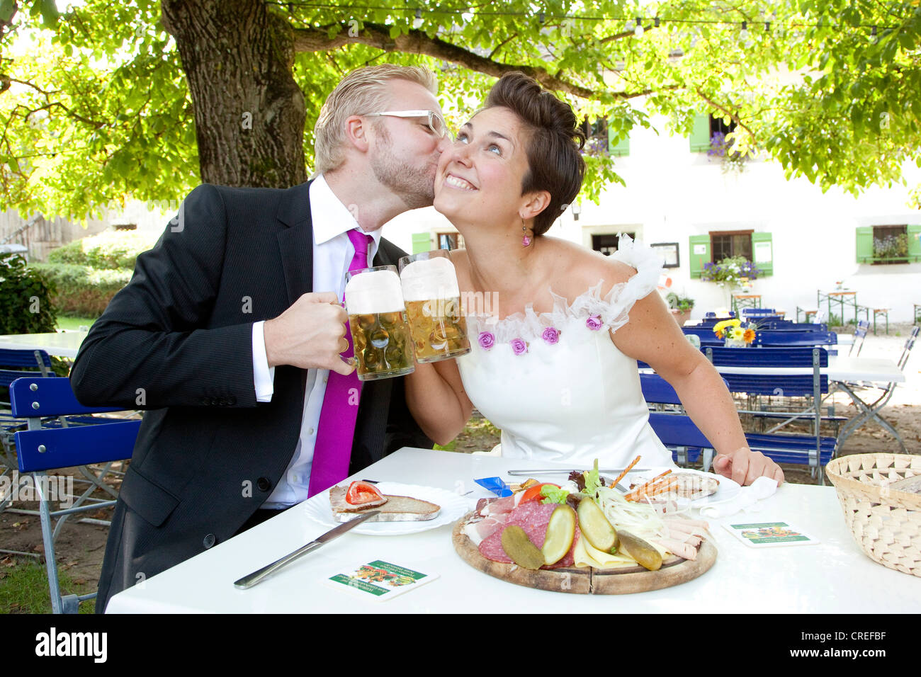 Pareja nupcial tener una comida ligera y bebiendo cerveza en un jardín de la cerveza de Baviera, Ratisbona, Baviera, Alemania, Europa Foto de stock