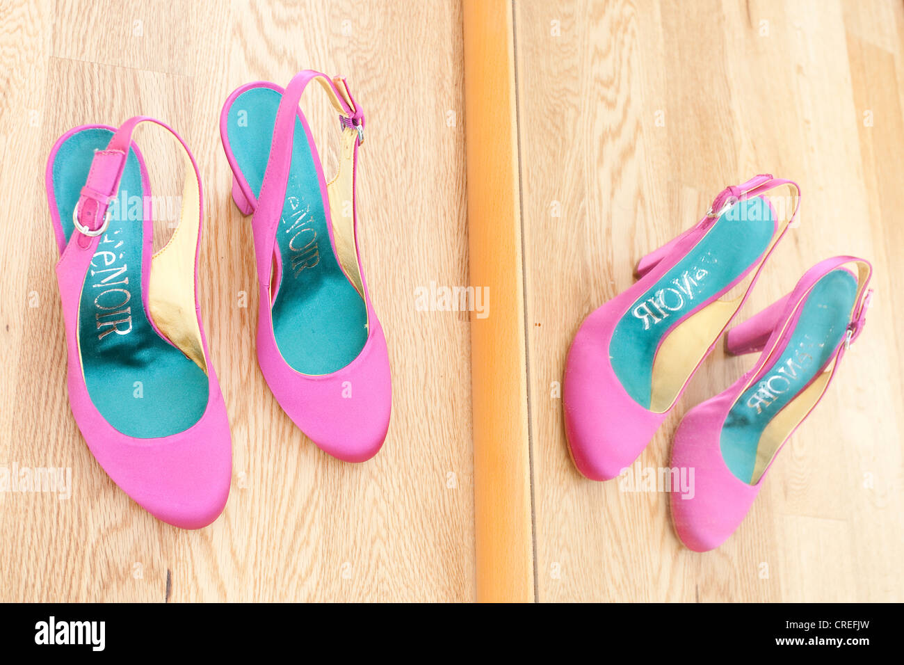 Zapatos de novia de pie delante de un espejo en el parquet Foto de stock