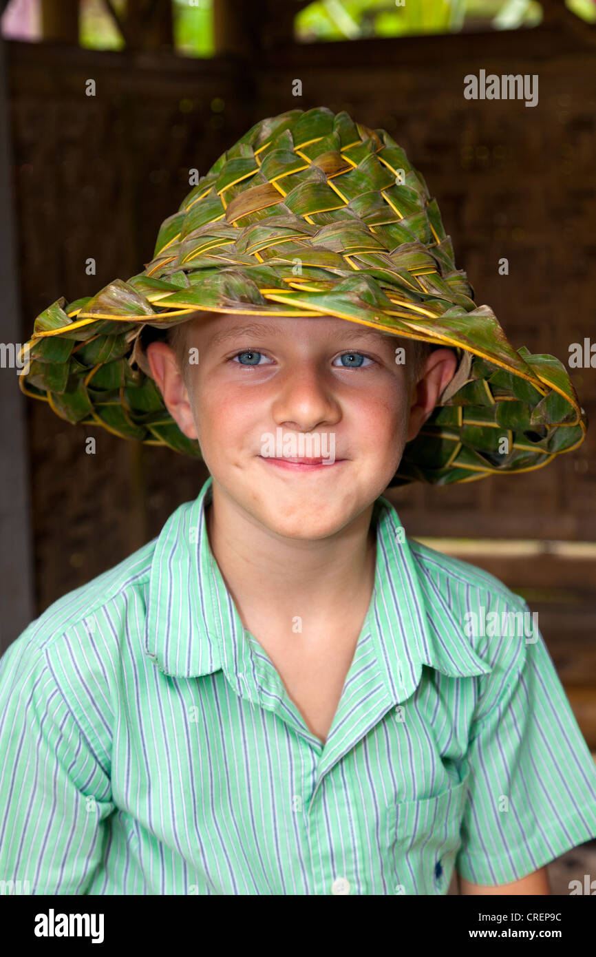 Niño usando un sombrero de hojas tejidas, cerca de Ubud, centro de Bali,  Bali, Indonesia, en el sudeste de Asia Fotografía de stock - Alamy