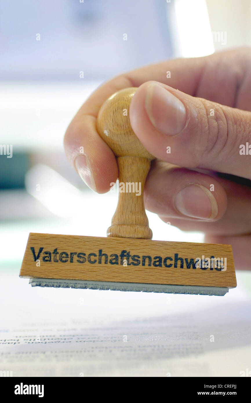 Mano con un sello Vaterschaftsnachweis, prueba de paternidad Foto de stock
