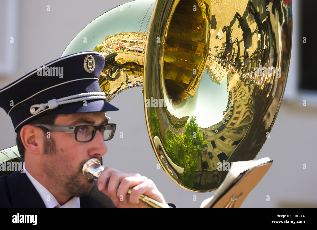 Tuba player, miembro de una banda callejera durante la procesión de baile.  En la tuba una imagen de espejo del Marquet Square y el d Fotografía de  stock - Alamy