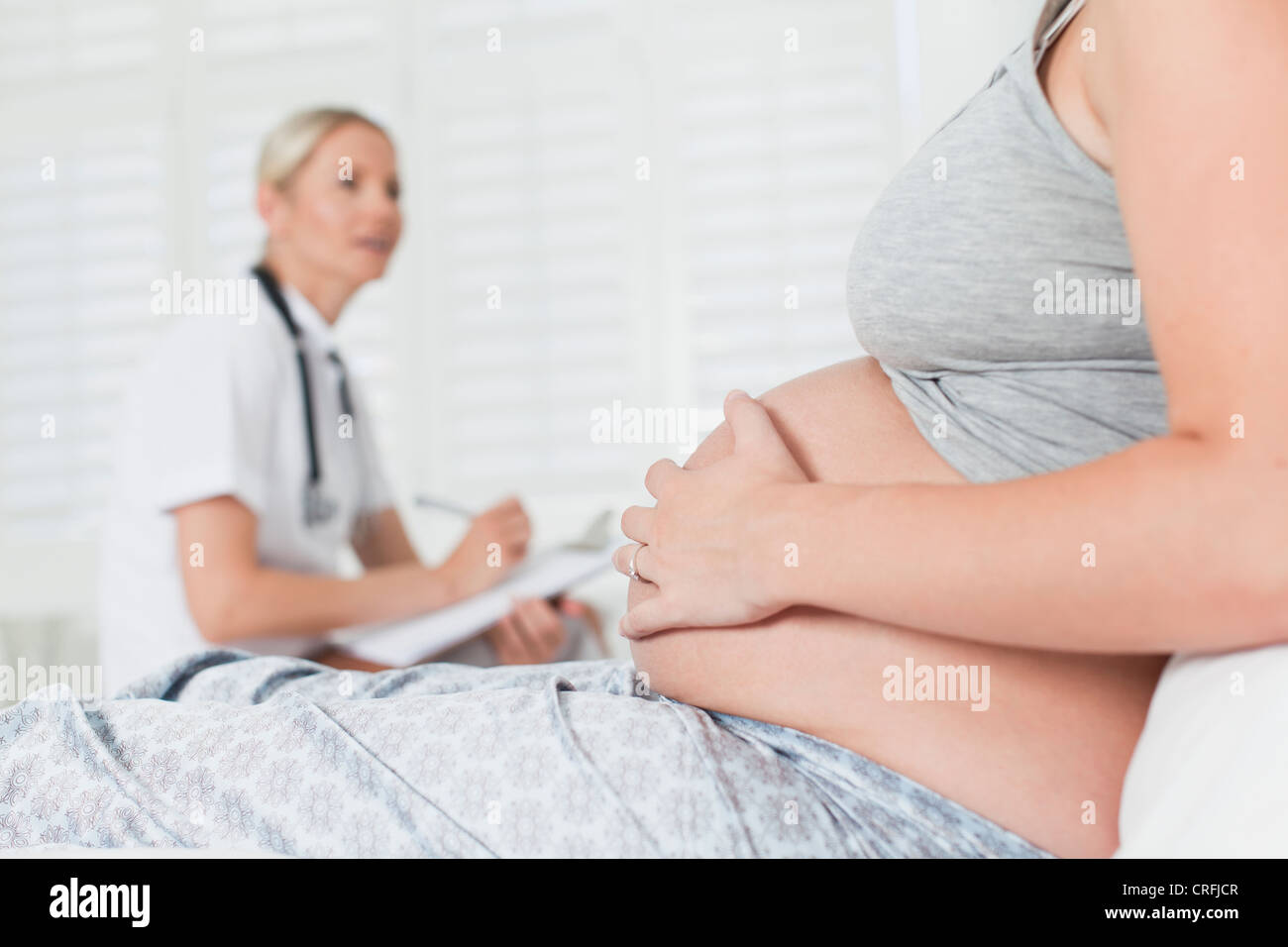 Doctor hablando a la mujer embarazada Foto de stock