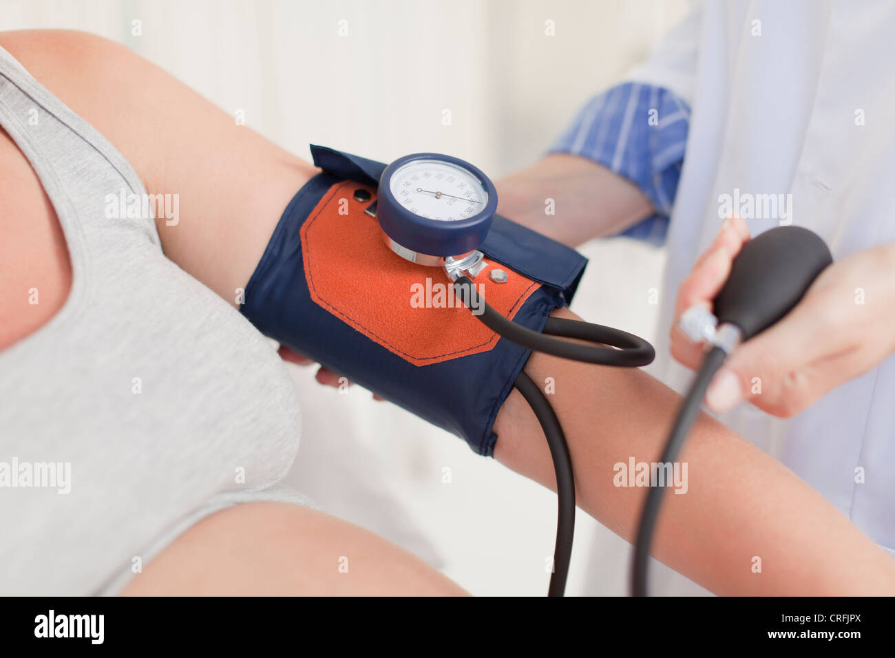 Doctor tomar la presión arterial de los womans Foto de stock