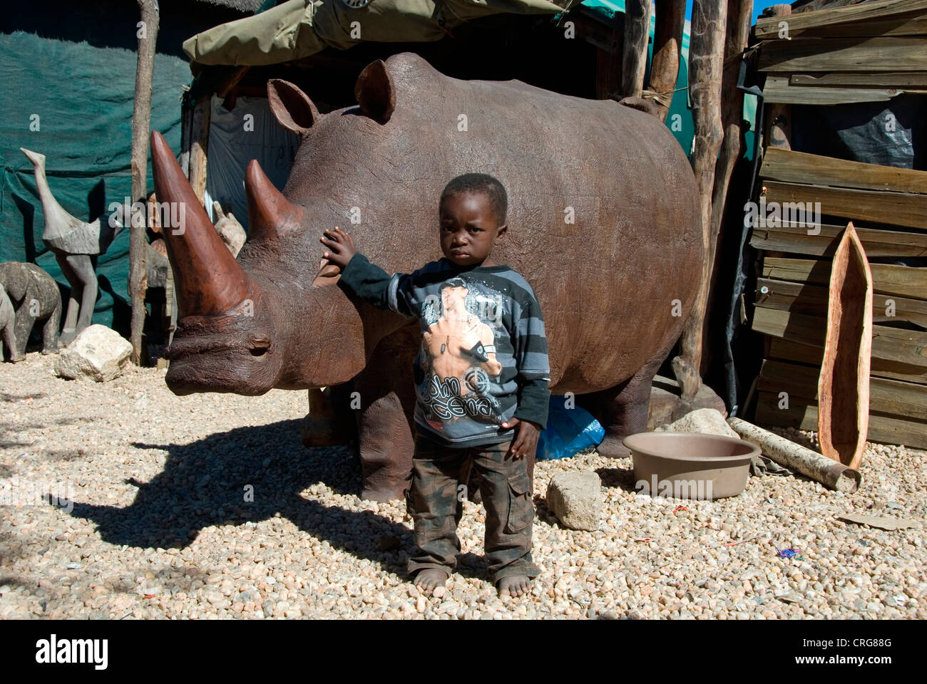 Figuras de madera, el muchacho en frente de un rinoceronte, Namibia, Okahandja Foto de stock