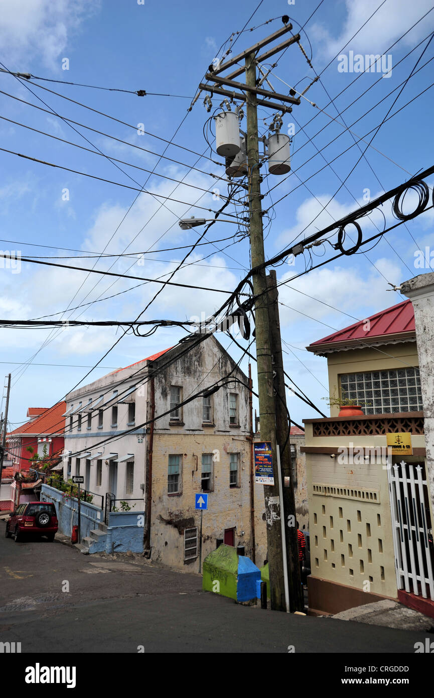 Una escena en la calle mostrando un poste de telégrafo con muchos cables en St George's, Granada, Indias Occidentales. Foto de stock