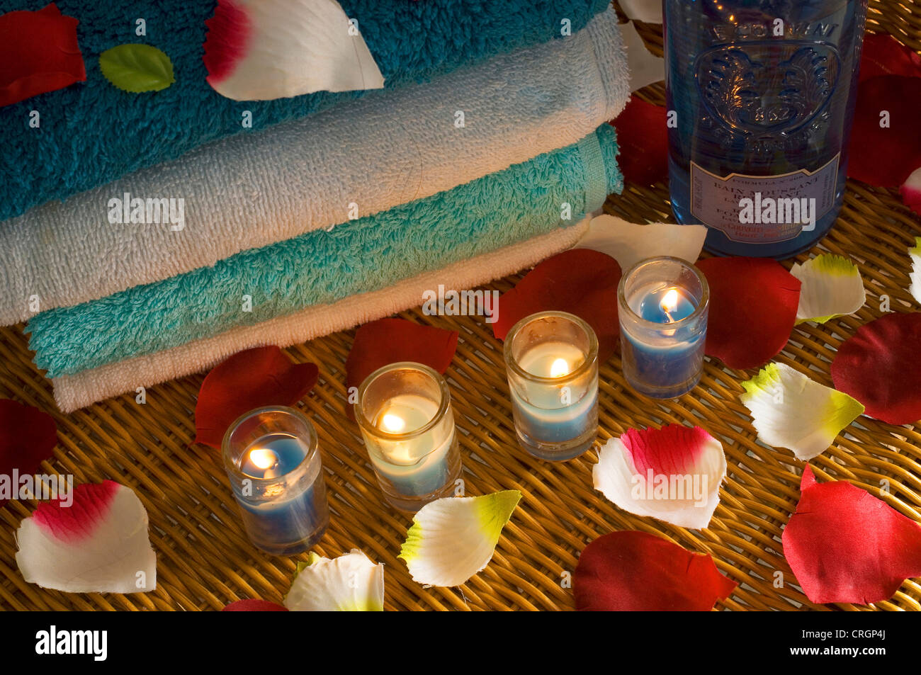 Los pétalos, la luz de las velas y toallas para la salud, el bienestar decoración Foto de stock