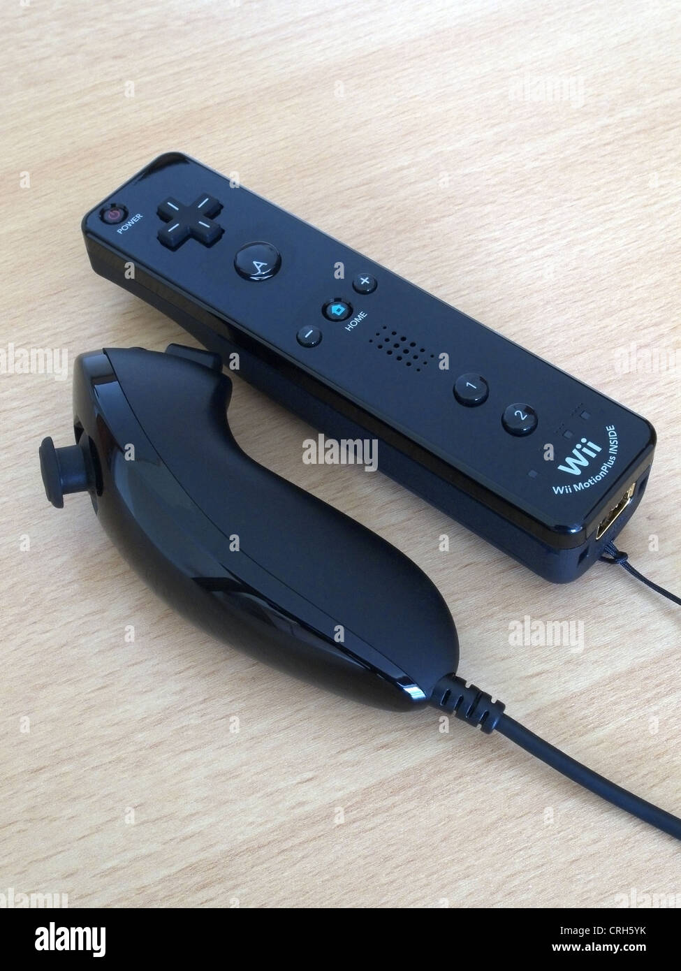 Nintendo Wii Remote y Nunchuck controlador negro sobre un fondo de madera Foto de stock