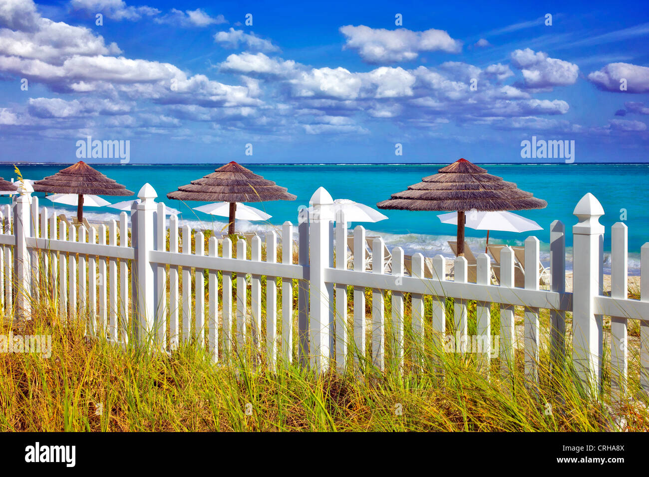 Valla blanca y sombrillas de playa. Grace Bay. Providenciales. Las Islas Turcas y Caicos Foto de stock