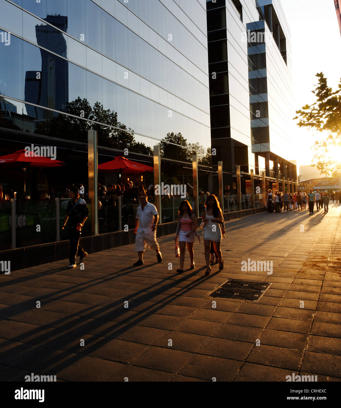 Largas sombras de gente que camina en la ciudad al atardecer Foto de stock