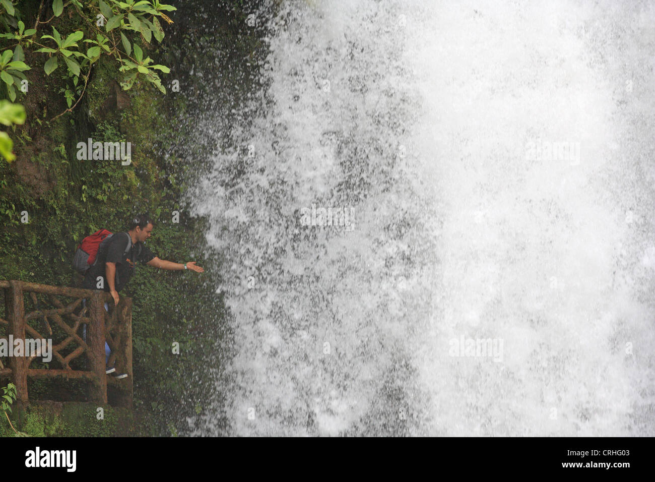 Turista en la cascada del Río Paz en La Paz Waterfall Gardens / Peace Lodge, cerca de Vara Blanca, Costa Rica. Foto de stock