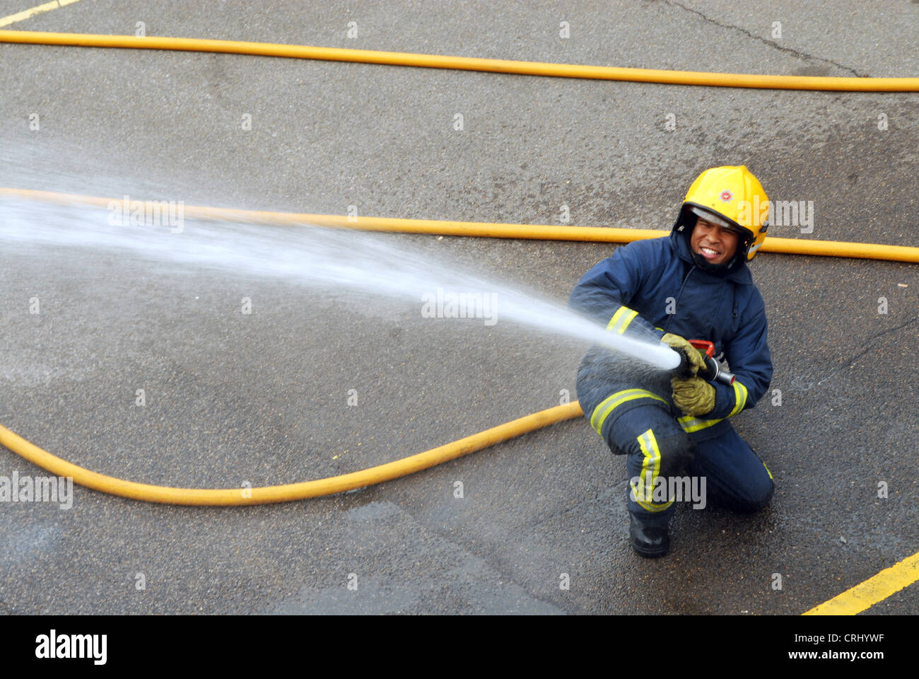 Un bombero usa una manguera de agua para sofocar un incendio Fotografía de  stock - Alamy