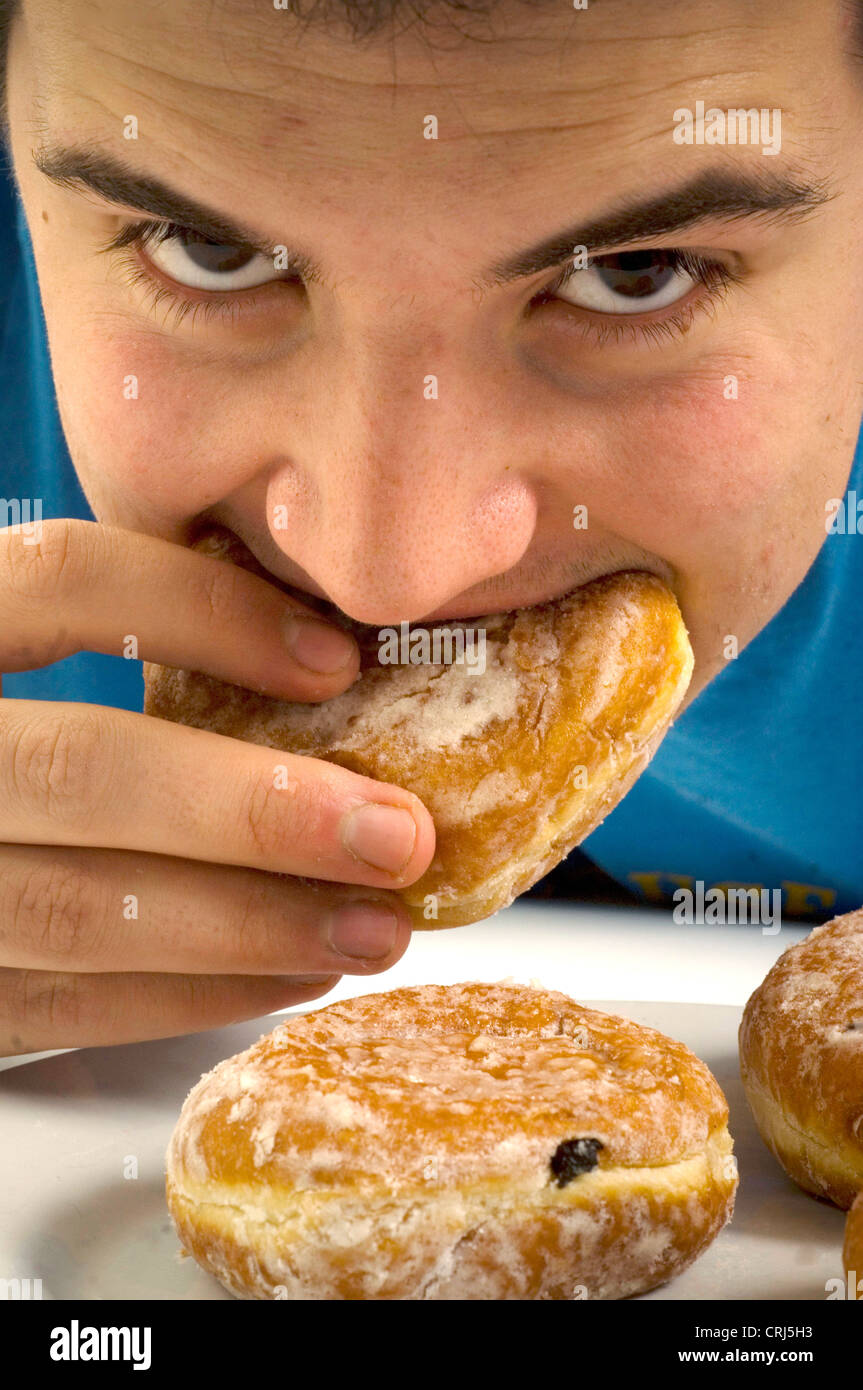 Un hombre joven jam donut junkie. Jam donuts han sido criticados por