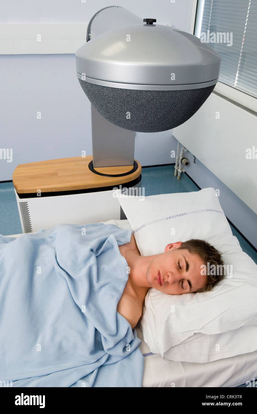 Hombre dormido en la cama de un hospital Foto de stock