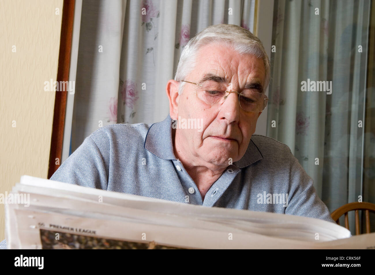 Anciano leyendo un periódico Foto de stock