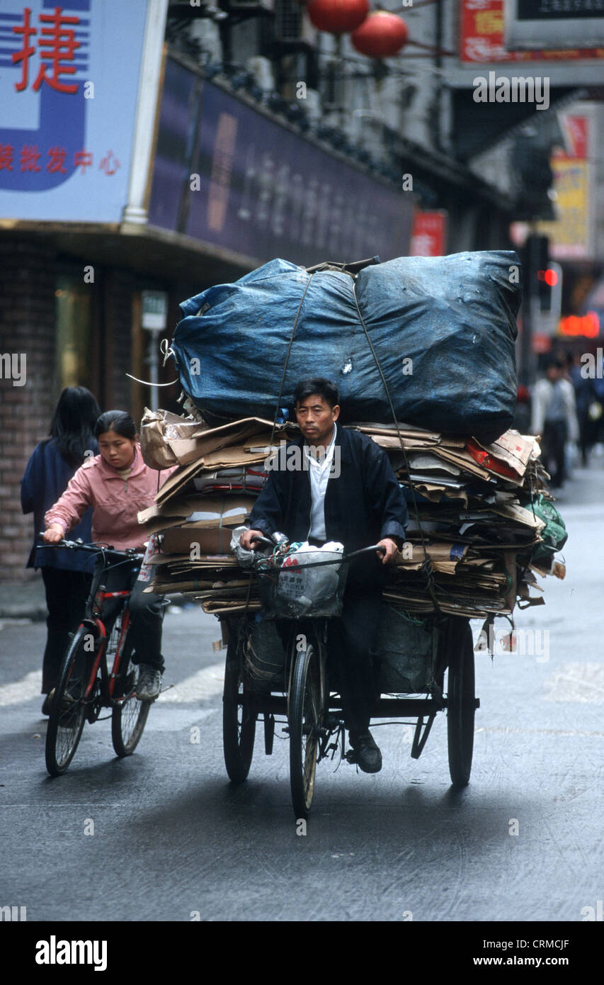 Carga pesada en los ciclistas en el centro de Shangai Foto de stock