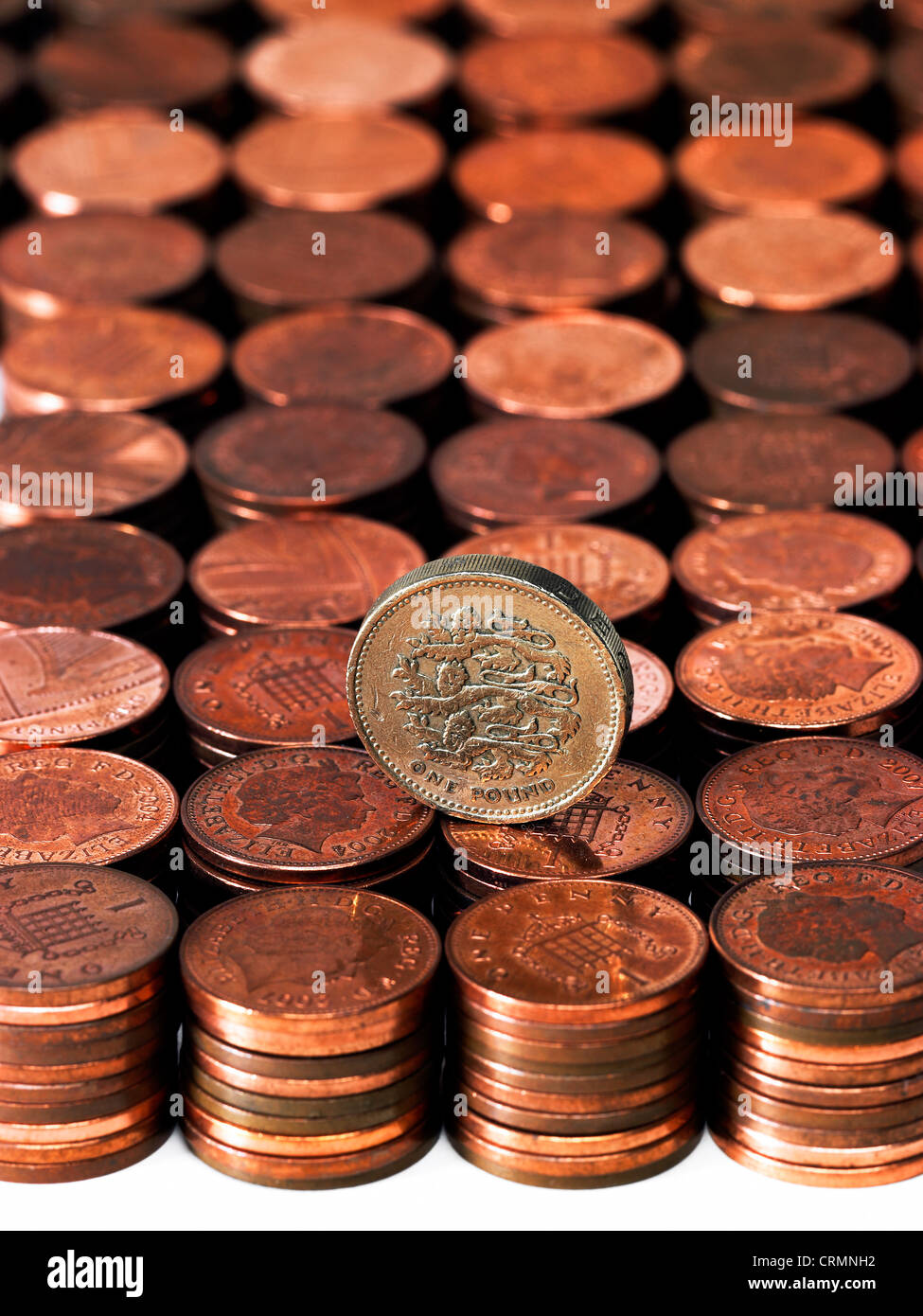 Prolijas pilas de British centavos con una sola moneda libra Foto de stock