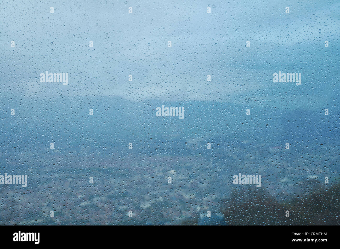 Gotas de lluvia en la ventana. En el fondo de la ciudad. Foto de stock