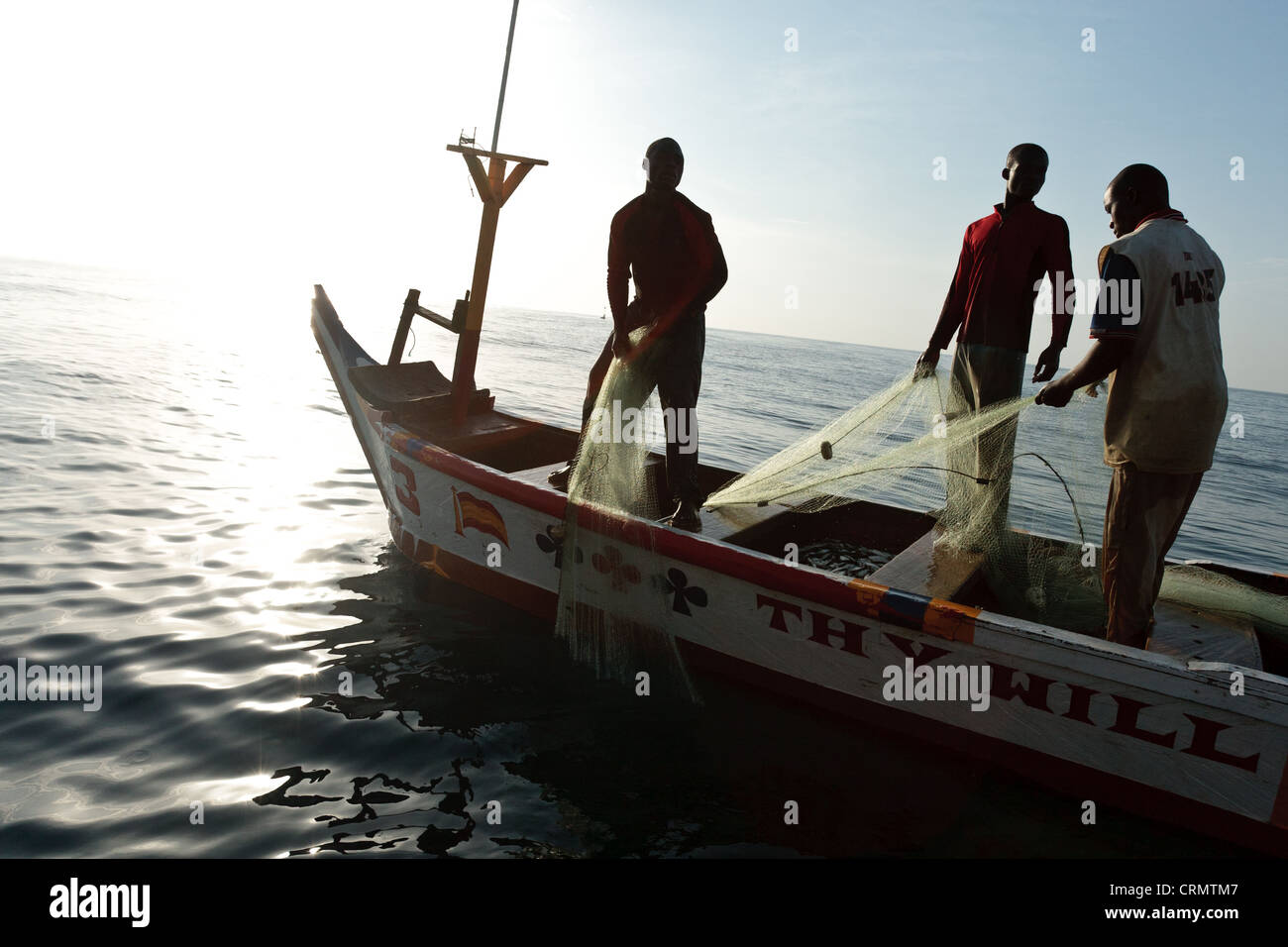 Tirar de los pescadores en sus redes mientras pescan en la costa cerca de Cape Coast, Ghana, Región Central. Foto de stock