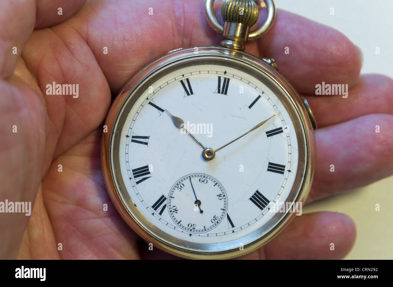 Comandante Desfavorable origen Un reloj de bolsillo de oro con números romanos y segundos marcar celebró  en mano Fotografía de stock - Alamy