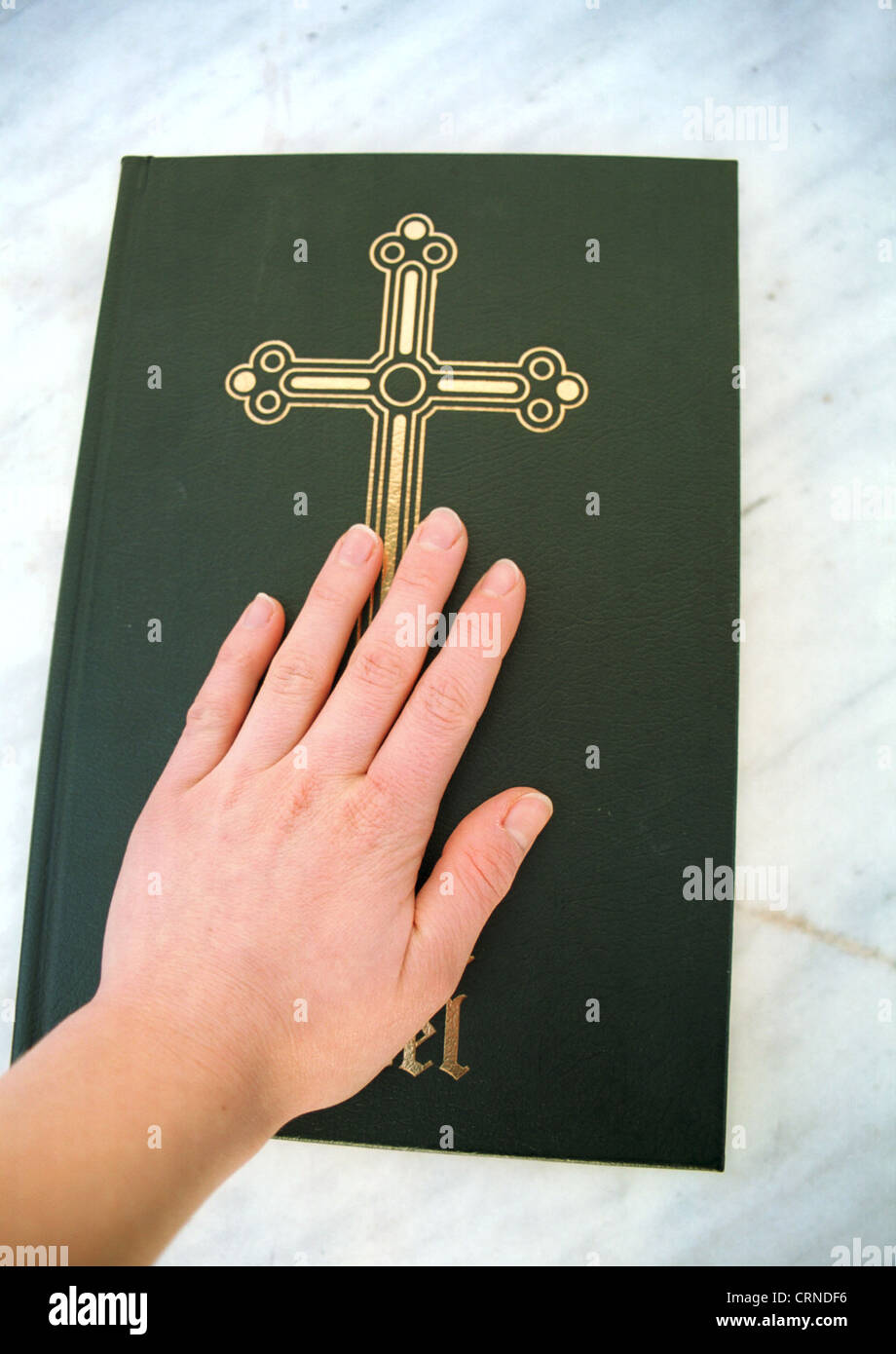 Una mano jura por la Biblia Foto de stock