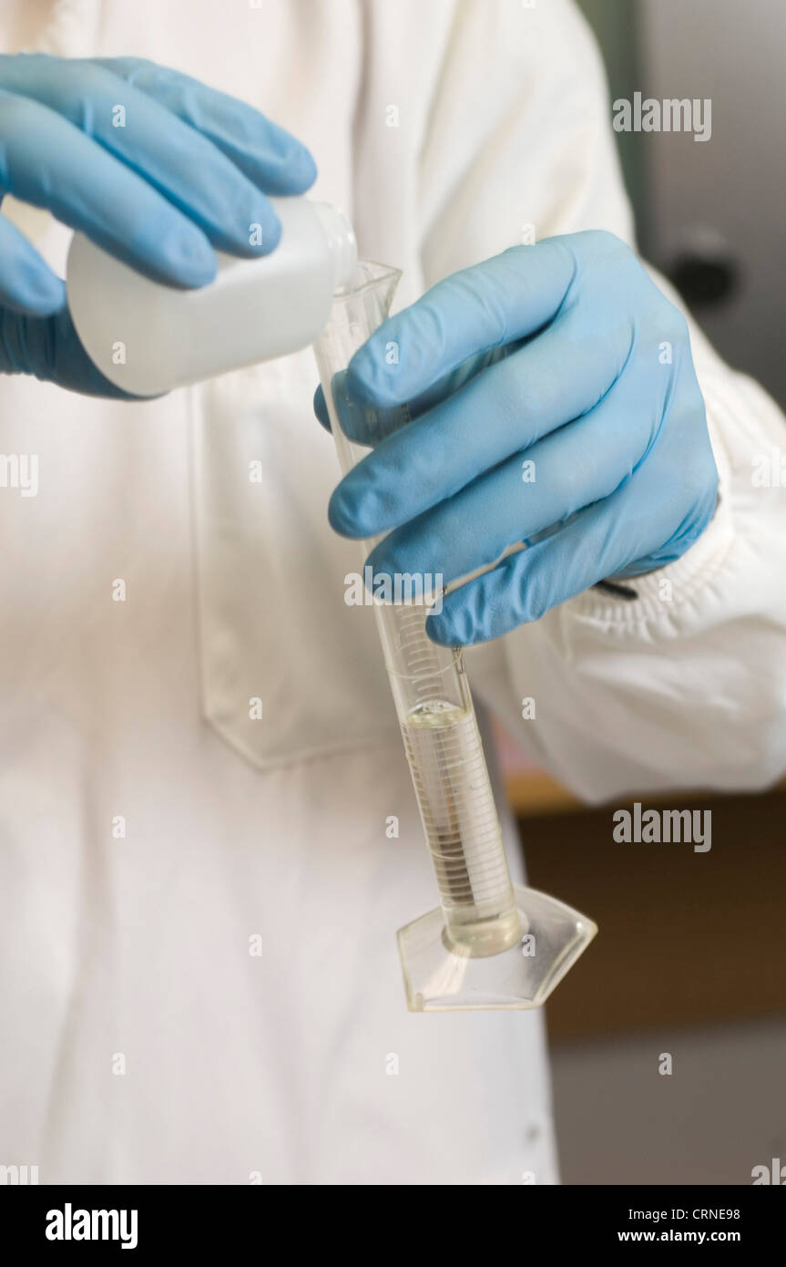 Un científico que mide una cantidad definida de un líquido claro Foto de stock